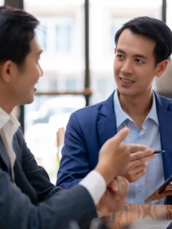 Two business professionals in a focused discussion at a corporate meeting