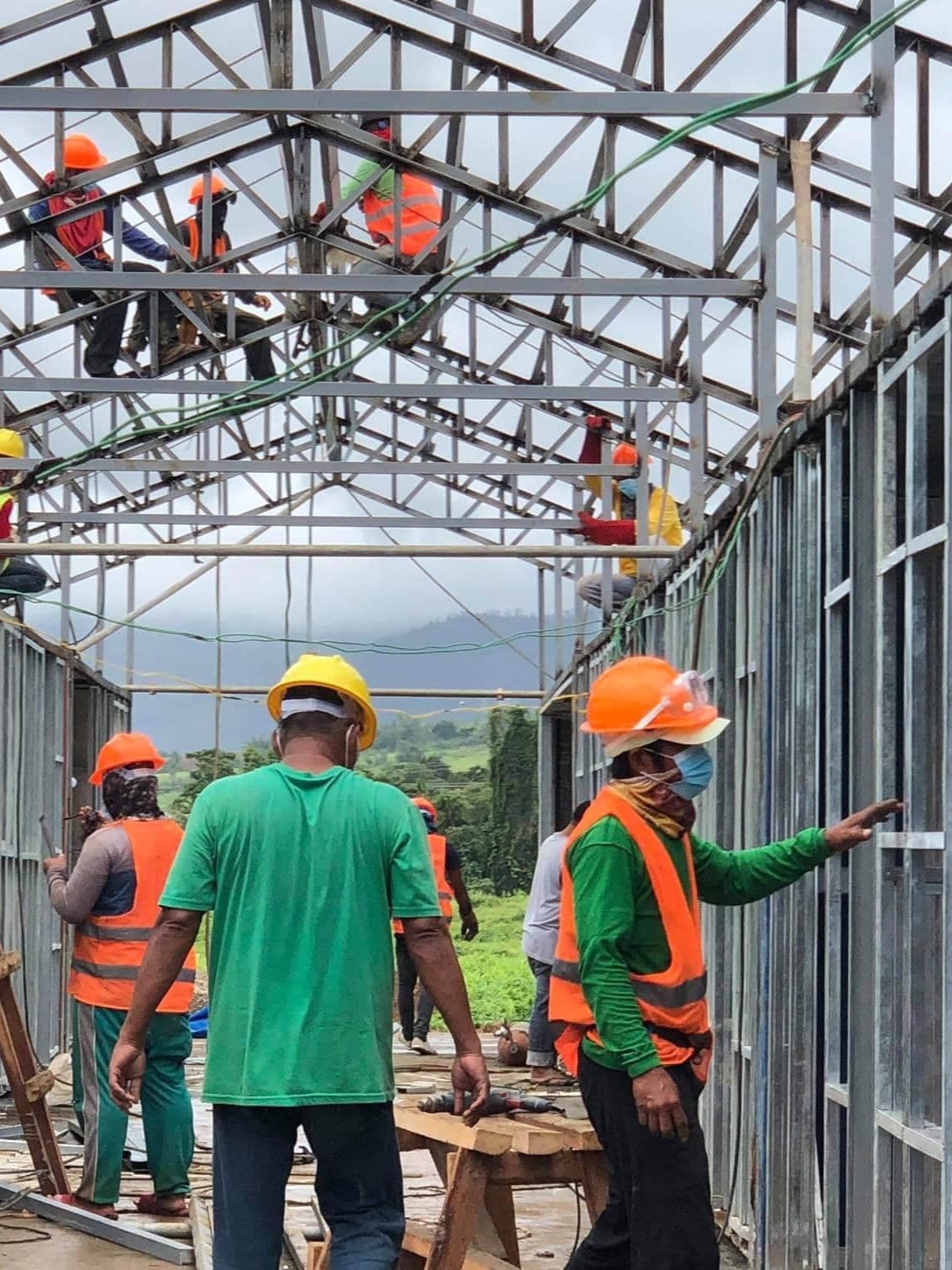 Construction crew assembling a steel structure on a field project